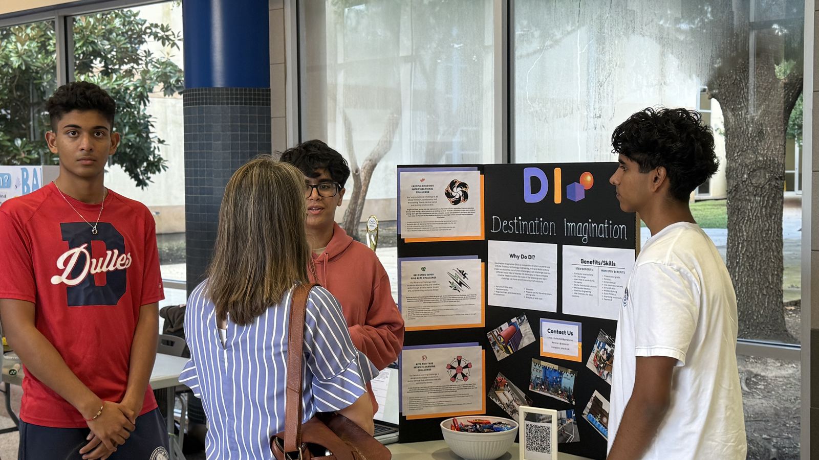 Two Trailblazers students at their DI booth with a Global Finals trophy